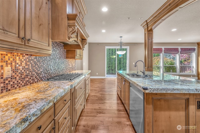 kitchen featuring an island with sink, stainless steel appliances, light hardwood / wood-style floors, and plenty of natural light