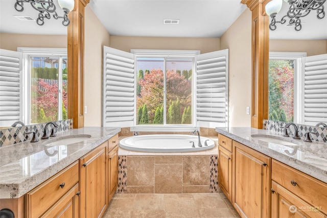 bathroom with vanity, tiled tub, and tile patterned flooring