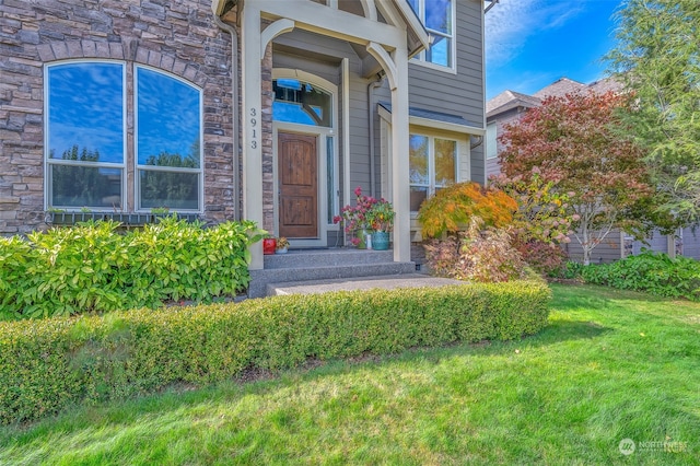 entrance to property featuring a yard