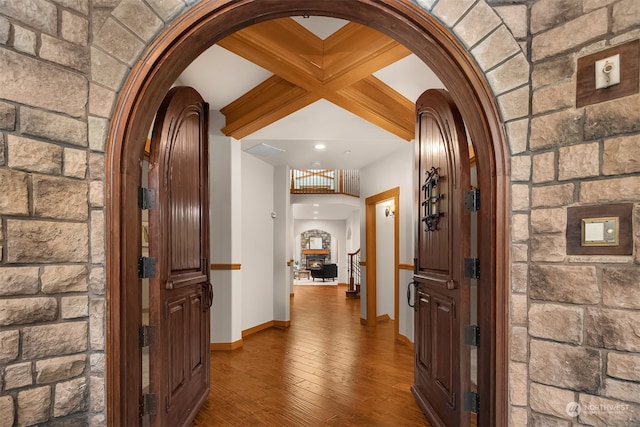 hallway with coffered ceiling, beamed ceiling, and dark wood-type flooring