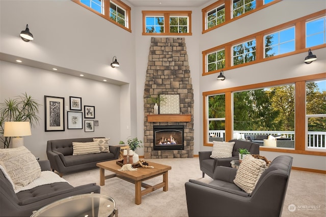 carpeted living room with a high ceiling and a stone fireplace