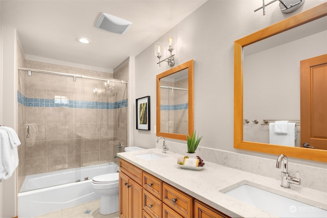 full bathroom featuring tile patterned floors, shower / bath combination with glass door, vanity, and toilet