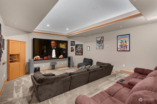 carpeted cinema room with a raised ceiling