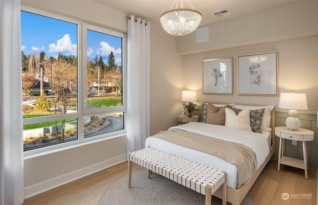 bedroom featuring light hardwood / wood-style flooring and a notable chandelier