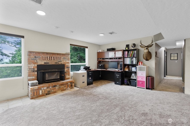 carpeted home office with a textured ceiling and plenty of natural light