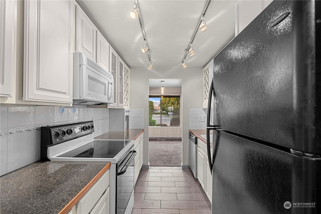 kitchen featuring range with electric cooktop, white cabinetry, black refrigerator, and stainless steel dishwasher