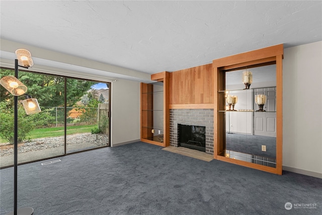 unfurnished living room featuring a brick fireplace and dark colored carpet