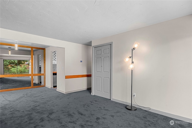 unfurnished room with dark carpet