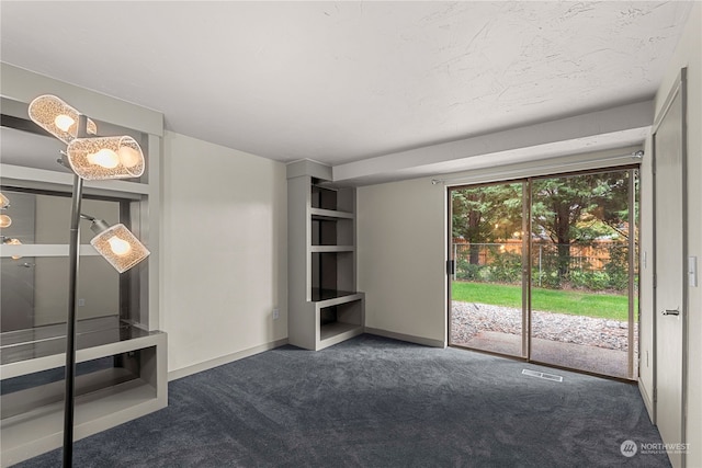 unfurnished living room with dark carpet