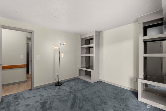 unfurnished living room with dark colored carpet