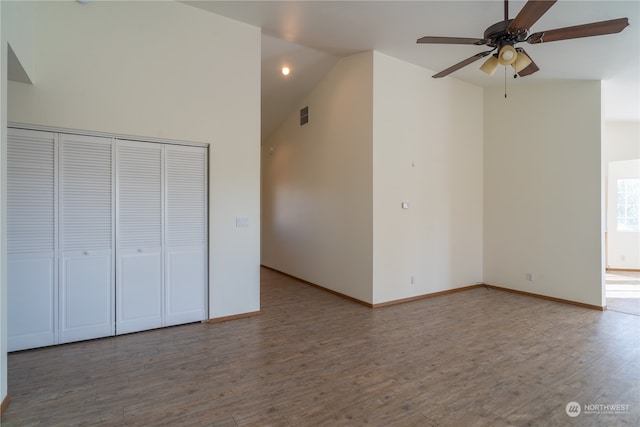 unfurnished bedroom with ceiling fan, high vaulted ceiling, hardwood / wood-style floors, and a closet