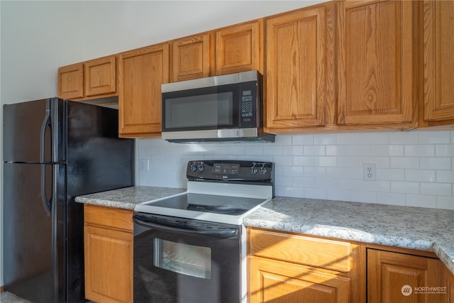 kitchen featuring tasteful backsplash and black appliances