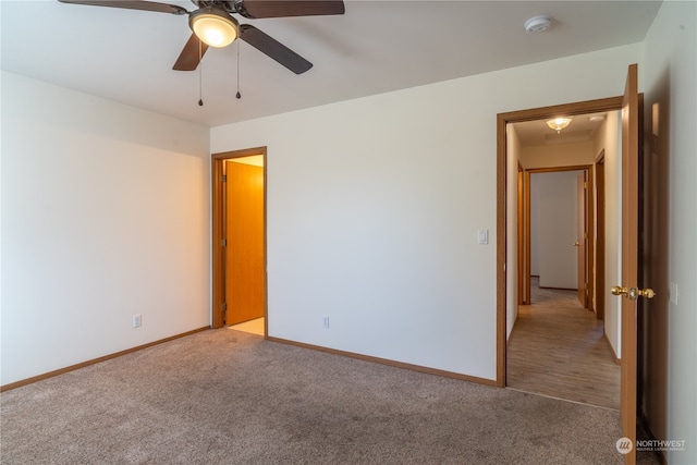 carpeted spare room featuring ceiling fan