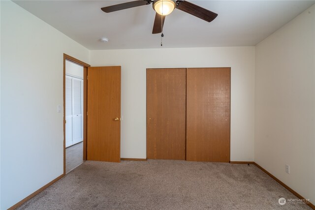 unfurnished bedroom featuring light colored carpet, a closet, and ceiling fan