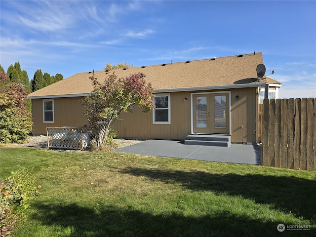 rear view of house featuring french doors, a patio area, and a lawn