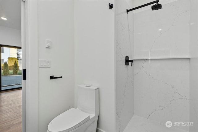 bathroom featuring hardwood / wood-style floors, toilet, a baseboard heating unit, and tiled shower