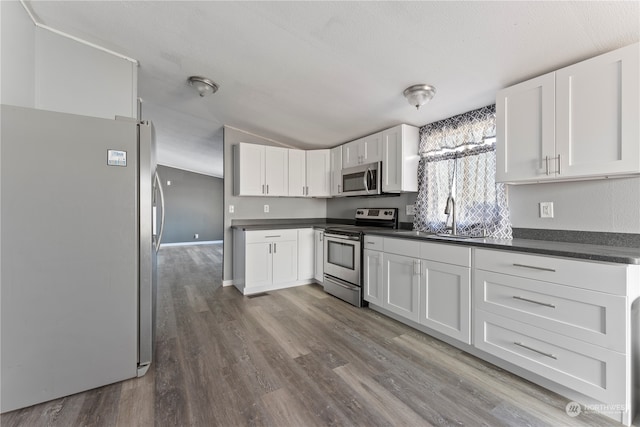 kitchen featuring appliances with stainless steel finishes, sink, hardwood / wood-style floors, and white cabinets