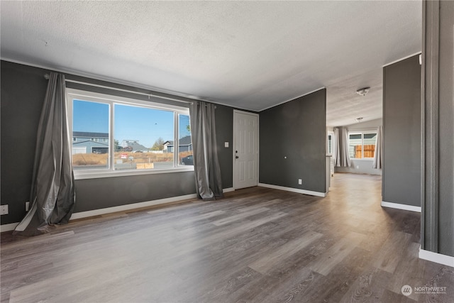 spare room with vaulted ceiling, hardwood / wood-style flooring, and a textured ceiling