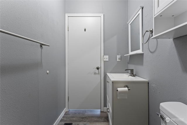 bathroom featuring hardwood / wood-style flooring, vanity, and toilet