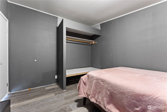 bedroom featuring wood-type flooring and a textured ceiling