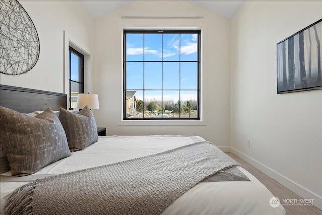 carpeted bedroom featuring lofted ceiling