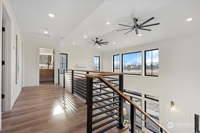 corridor with hardwood / wood-style flooring and vaulted ceiling