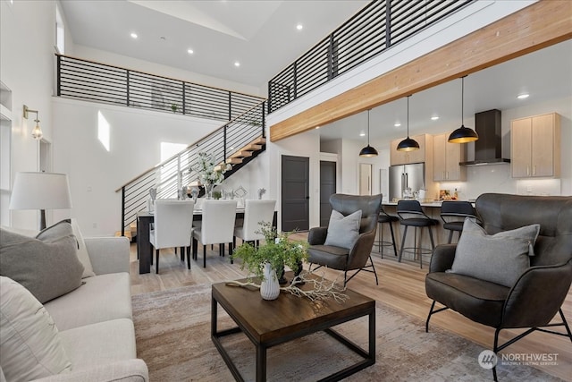 living room with a towering ceiling and light hardwood / wood-style floors