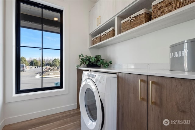 laundry area featuring washer / dryer, dark wood-type flooring, and cabinets