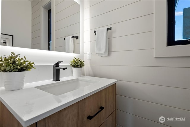 bathroom with vanity and wooden walls