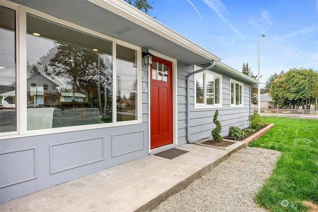 view of exterior entry with a lawn