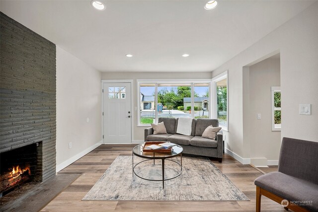 living room featuring hardwood / wood-style flooring and a brick fireplace