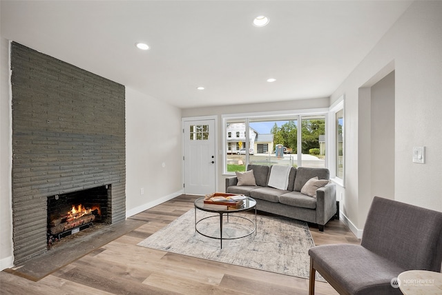 living room featuring light hardwood / wood-style flooring and a stone fireplace