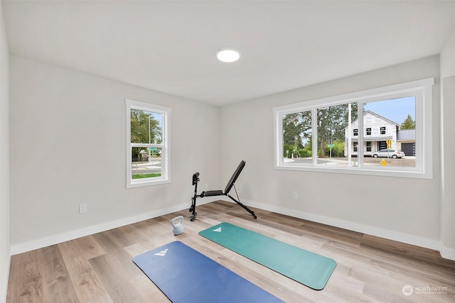 exercise room with light wood-type flooring