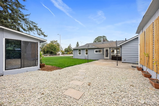 rear view of property featuring a yard and a patio