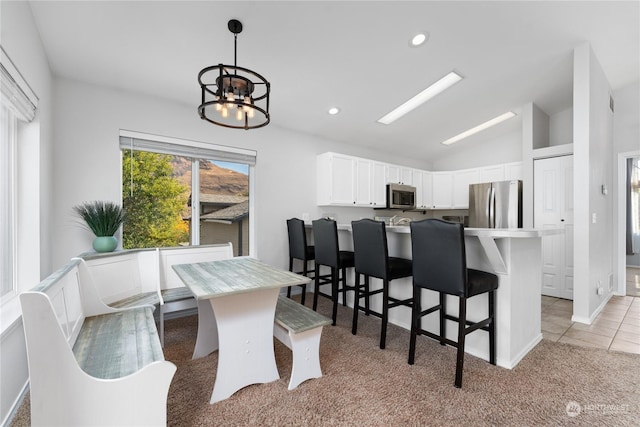 260 Chestnut St, Chelan Falls, WA 98817 - kitchen featuring white cabinets, stainless steel appliances, a chandelier, light colored carpet, and lofted ceiling
