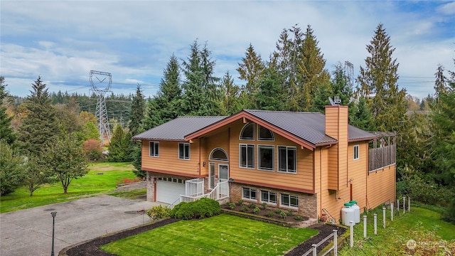 raised ranch featuring a front yard and a garage