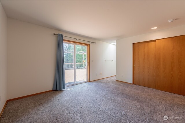 unfurnished bedroom featuring access to outside, a closet, and carpet