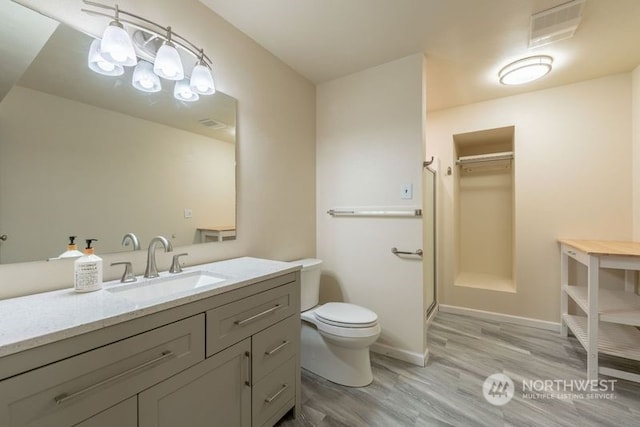 bathroom featuring vanity, toilet, hardwood / wood-style floors, and an enclosed shower