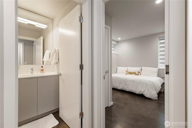 bathroom with recessed lighting, finished concrete floors, decorative backsplash, and vanity