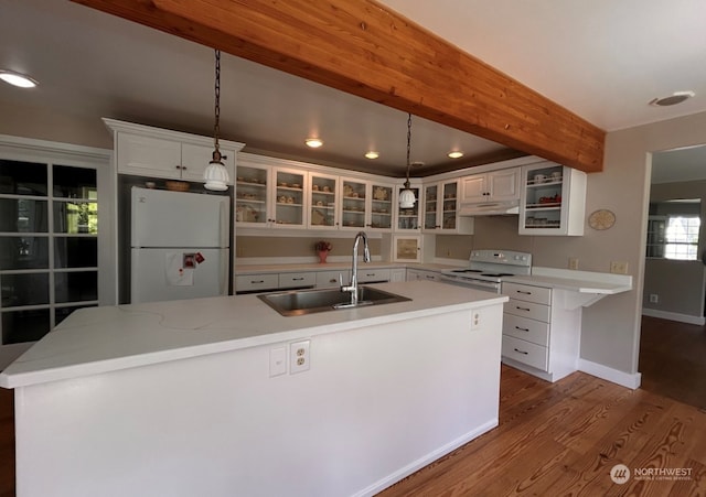 kitchen featuring white cabinets, sink, white appliances, decorative light fixtures, and hardwood / wood-style floors