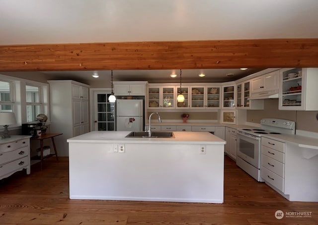 kitchen featuring a kitchen island with sink, pendant lighting, white appliances, sink, and white cabinetry