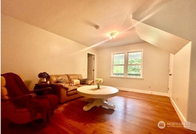 interior space featuring hardwood / wood-style flooring and vaulted ceiling