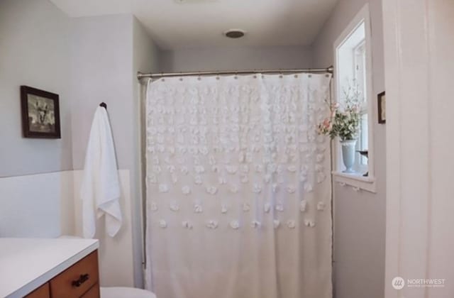 bathroom with vanity, walk in shower, and toilet