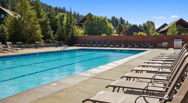 community pool featuring fence and a patio