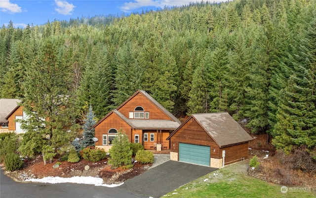 view of front of house with a garage and a view of trees