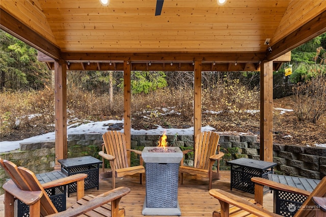 wooden terrace with a fire pit and a gazebo