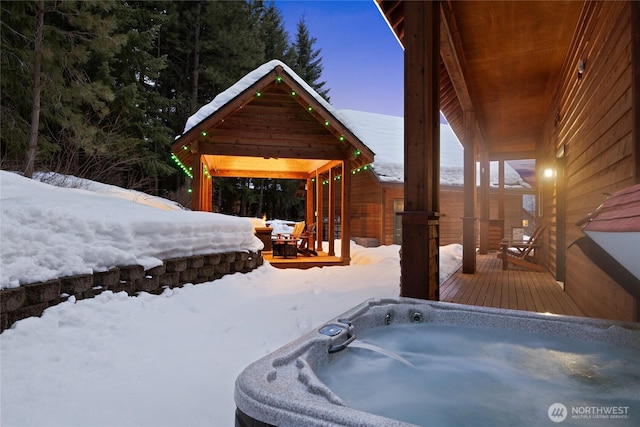 snowy yard with a hot tub and a wooden deck