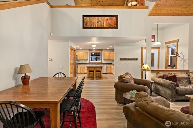 living room with light wood finished floors, a high ceiling, and recessed lighting