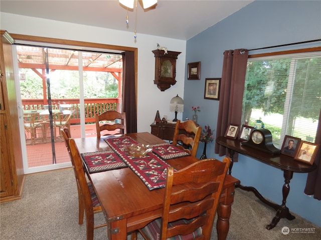 carpeted dining room featuring ceiling fan and vaulted ceiling