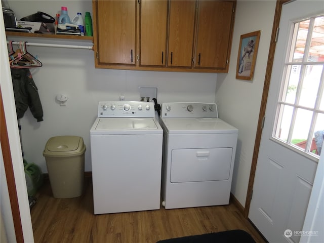 laundry room featuring light hardwood / wood-style flooring, cabinets, and washer and clothes dryer